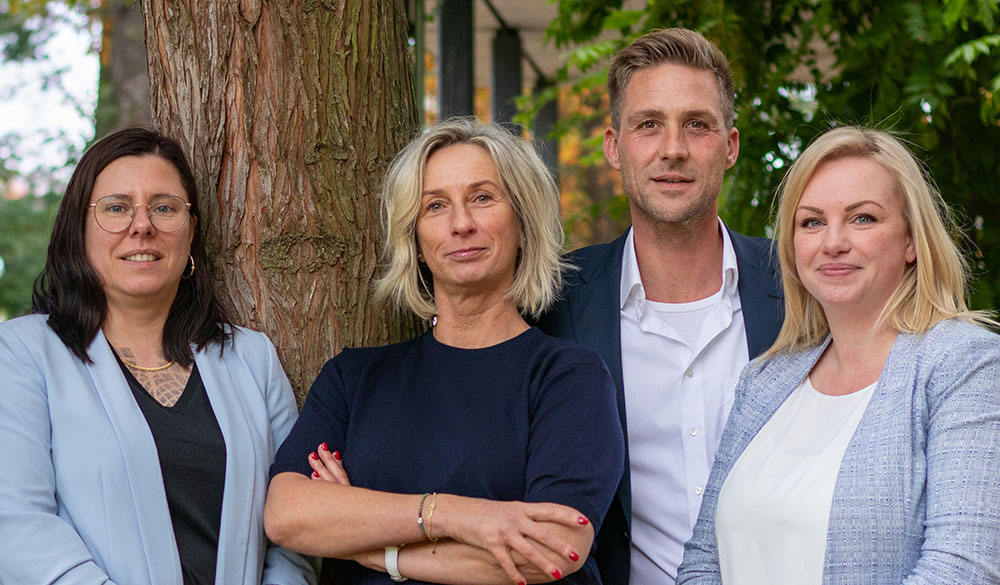vent immobilien team steht um einen Baum